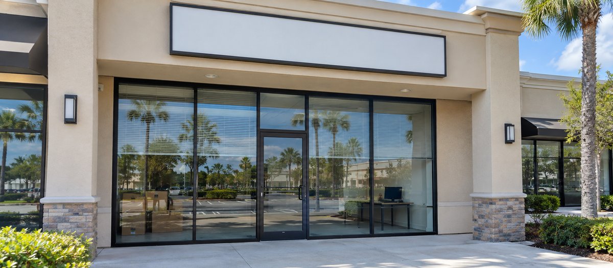 Empty office unit in a Florida shopping plaza with a blank sign, after a company has closed